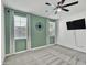 Bedroom features decorative compass, mounted TV, ceiling fan, carpet and bright windows at 8140 W Lane Ave, Glendale, AZ 85303