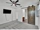 The main bedroom boasts an ensuite bath, ceiling fan, a mounted TV and carpet at 8140 W Lane Ave, Glendale, AZ 85303