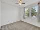 Well-lit bedroom features a ceiling fan, soft carpet, and bright windows with natural light at 8140 W Lane Ave, Glendale, AZ 85303