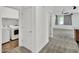 Well-lit hallway features a laundry closet and leads into an open living area with neutral carpet at 8140 W Lane Ave, Glendale, AZ 85303