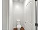 Simple powder room with a toilet, wood-look flooring and white door at 8140 W Lane Ave, Glendale, AZ 85303