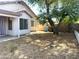Spacious backyard with ample potential, shaded by a large tree, and enclosed by a brick wall for privacy at 8308 W Baxter Dr, Phoenix, AZ 85037