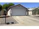 Traditional single-story home featuring a two-car garage and neutral desert landscape at 8308 W Baxter Dr, Phoenix, AZ 85037