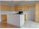 Kitchen features wooden cabinets, white counters, and island with sink at 8308 W Baxter Dr, Phoenix, AZ 85037