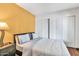 Bright bedroom with a queen bed and a yellow accent wall, complemented by minimalist decor and closet with sliding doors at 8532 E San Bruno Dr, Scottsdale, AZ 85258