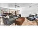 Open living area with gray sofas, a ceiling fan, and tile flooring leads to an open kitchen and dining area at 8532 E San Bruno Dr, Scottsdale, AZ 85258