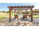 Inviting backyard pergola with seating, offering a relaxing spot near the pool and lush landscaping at 8532 E San Bruno Dr, Scottsdale, AZ 85258