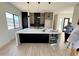 A modern kitchen with a large island, stainless steel appliances, and sleek black and wood cabinetry at 9027 S 19Th St, Phoenix, AZ 85042