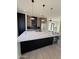 A modern kitchen with a large island, stainless steel appliances, and sleek black and wood cabinetry at 9027 S 19Th St, Phoenix, AZ 85042