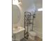 Cozy bathroom featuring a pedestal sink, matching toilet and a black metal shelving unit for practical storage at 9233 E Neville Ave # 1011, Mesa, AZ 85209