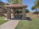 Community pavilion featuring a stone facade, shaded picnic table, and peaceful park views at 9233 E Neville Ave # 1011, Mesa, AZ 85209