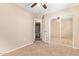 A bedroom with a ceiling fan, sliding mirror closet door, and connecting bathroom at 9233 E Neville Ave # 1127, Mesa, AZ 85209