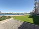 Beautiful backyard overlooking a lake with palm trees and a green lawn at 10330 W Thunderbird Blvd # B112, Sun City, AZ 85351