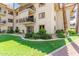 Well-maintained three-story condo building featuring balconies, green grass, and mature landscaping at 10330 W Thunderbird Blvd # B112, Sun City, AZ 85351