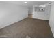 Spacious living area with neutral carpeting and seamless transitions to other living spaces at 10831 W Heatherbrae Dr, Phoenix, AZ 85037