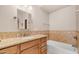 Clean bathroom with tan tiled backsplash, light wood cabinets, and bathtub at 116 E Mountain Sky Ave, Phoenix, AZ 85048