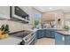 Bright kitchen featuring blue lower cabinets, quartz countertops, and stainless steel appliances at 116 E Mountain Sky Ave, Phoenix, AZ 85048