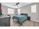 Bedroom with wood-look floors, ceiling fan, two bright windows, and dark furniture at 11952 W Villa Chula Ln, Sun City, AZ 85373