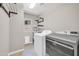 Functional laundry room with modern washer and dryer, shelving, and natural light at 11952 W Villa Chula Ln, Sun City, AZ 85373