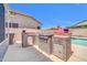 Outdoor kitchen featuring a built-in grill, mini-fridge, and stone accents, perfect for backyard entertaining at 11952 W Villa Chula Ln, Sun City, AZ 85373