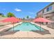 Backyard pool is flanked by sunny umbrellas, lounge chairs, and desert landscaping at 11952 W Villa Chula Ln, Sun City, AZ 85373