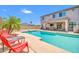 Backyard oasis features a pool, comfortable seating and lush palm trees, perfect for outdoor relaxation at 11952 W Villa Chula Ln, Sun City, AZ 85373