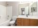 Bathroom featuring a light wood vanity, large mirror, and shower-tub combo with tile flooring at 12274 W Monroe St, Avondale, AZ 85323