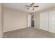 This bedroom features neutral walls, a ceiling fan, carpet and a mirrored door closet at 12274 W Monroe St, Avondale, AZ 85323