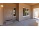 Covered front porch with a brown entry door and security screen at 12274 W Monroe St, Avondale, AZ 85323