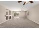 Inviting living room with a fireplace, built-in shelving, neutral walls, and carpeted floors at 12274 W Monroe St, Avondale, AZ 85323