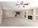 A well lit Living Room, features a fireplace, built-in shelving, neutral walls and carpeted floors at 12274 W Monroe St, Avondale, AZ 85323