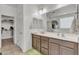 Spacious bathroom featuring double sinks, a large mirror, and a view of a walk-in closet at 12375 W Whyman Ave, Avondale, AZ 85323