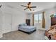 Bedroom features a ceiling fan, wood-look tile floors and a window with tan drapes at 12375 W Whyman Ave, Avondale, AZ 85323