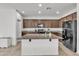Kitchen features dark wood cabinets, granite counters, tile floors and black appliances at 12375 W Whyman Ave, Avondale, AZ 85323