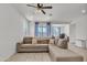 Living room with fan, tiled floors and large gray sectional sofa at 12375 W Whyman Ave, Avondale, AZ 85323