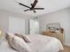 Main bedroom with a large bed, ensuite bathroom, a dresser, and a ceiling fan, providing a tranquil and well-appointed suite at 12641 S 39Th Pl, Phoenix, AZ 85044