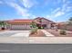 A beautiful single-story house featuring a three car garage, red tile roof, and desert landscape at 12641 S 39Th Pl, Phoenix, AZ 85044