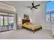Sunlit main bedroom with high ceilings, ceiling fan, and sliding glass door to the patio at 12641 S 39Th Pl, Phoenix, AZ 85044