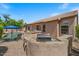 Exterior shot of a house featuring a backyard with a built in bbq, seating, a pool, and lush trees at 1321 E Monteleone St, San Tan Valley, AZ 85140