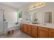 Bright bathroom featuring double sinks, a soaking tub, a separate shower, and ample storage space at 1321 E Monteleone St, San Tan Valley, AZ 85140
