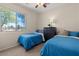Cozy bedroom featuring two twin beds, a large window offering ample natural light, and neutral decor at 1321 E Monteleone St, San Tan Valley, AZ 85140