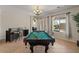 Open game room featuring a pool table, bar, and bright natural lighting at 1321 E Monteleone St, San Tan Valley, AZ 85140