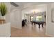 Spacious game room with an elegant chandelier, a pool table, and an open archway to the rest of the home at 1321 E Monteleone St, San Tan Valley, AZ 85140