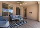 Relaxing covered patio seating area with stylish decor and a tranquil backyard view at 1321 E Monteleone St, San Tan Valley, AZ 85140