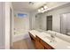 Bright bathroom with a wide mirror, dual vanity, and shower-tub combo at 1415 E Chipman Rd, Phoenix, AZ 85040