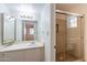 Bathroom with white vanity, glass shower, and open doorway to room with wooden floors at 1446 E Grovers Ave # 13, Phoenix, AZ 85022