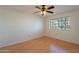 An empty bedroom features light wood floors, a ceiling fan, and a window at 1446 E Grovers Ave # 13, Phoenix, AZ 85022