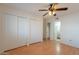A spacious bedroom features wood floors, ceiling fan, closet, and bathroom access at 1446 E Grovers Ave # 13, Phoenix, AZ 85022