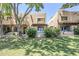 Charming townhome with well-manicured lawn, mature trees, and welcoming sign with light blue door and window trim at 1446 E Grovers Ave # 13, Phoenix, AZ 85022