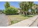 View of the home's exterior with mature trees and grassy area at 1446 E Grovers Ave # 13, Phoenix, AZ 85022